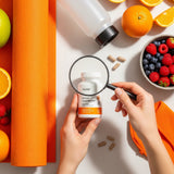 A person closely examines the label of a nutrition supplement bottle with a magnifying glass, surrounded by healthy items, illustrating how to choose the right supplement.